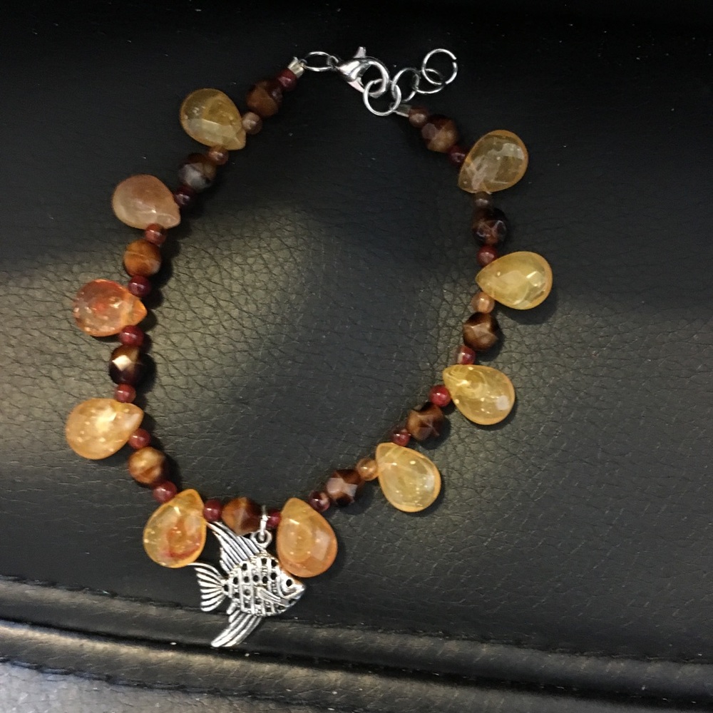 Orange and brown beaded bracelet with fish charm
